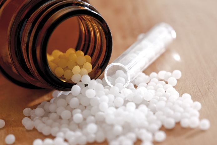 Homeopathic pills spilling from bottle, close-up homeopathy