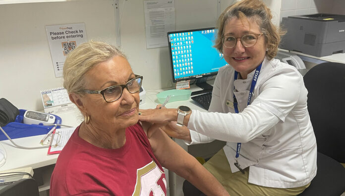 qld-pharm-vax-feature Pharmacist Sarah Parry-Okeden vaccinating a patient at Acton Health Pharmacy
