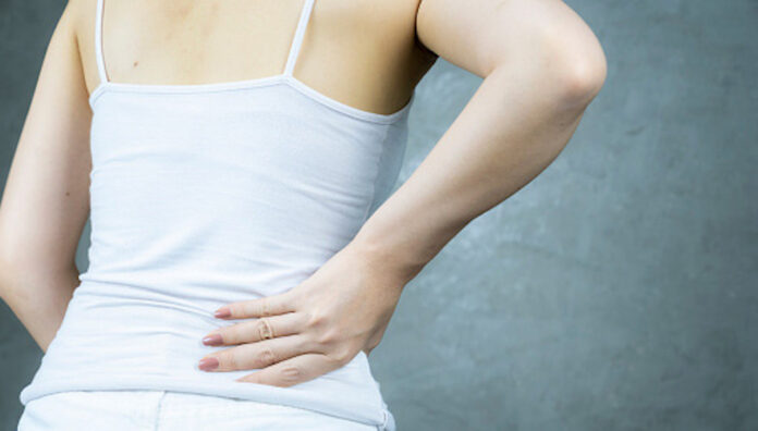 Midsection of female has suffering backache against form work hard