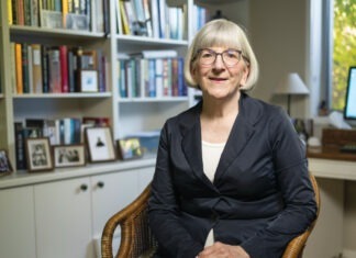 PSA’s resident accredited pharmacist Photo of Sarah Gillespie MPS sitting down inside her library